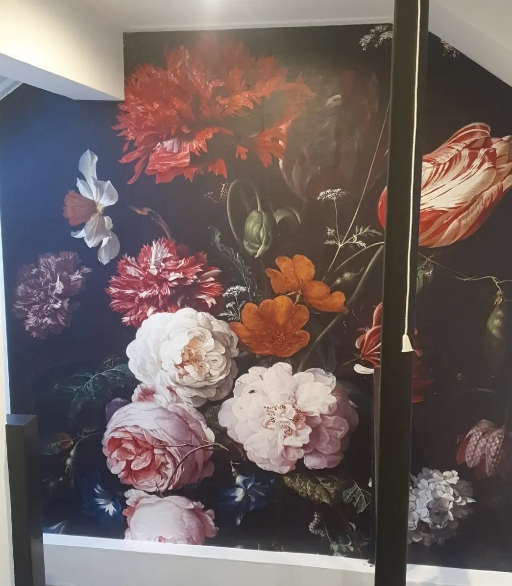 Donkere wand met een grote bloemenprint in een trapgat