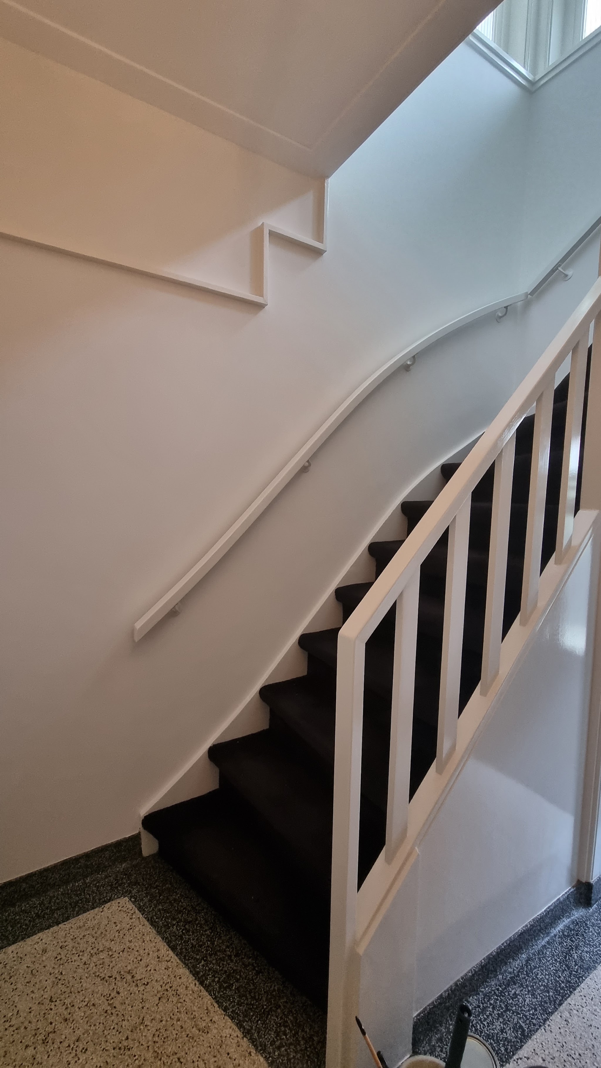 Wit geschilderde trap met leuning en spijlen